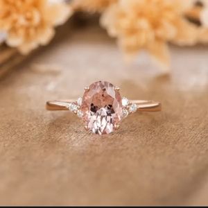 Rose gold ring with pink oval gem and diamond accents. Size 11.